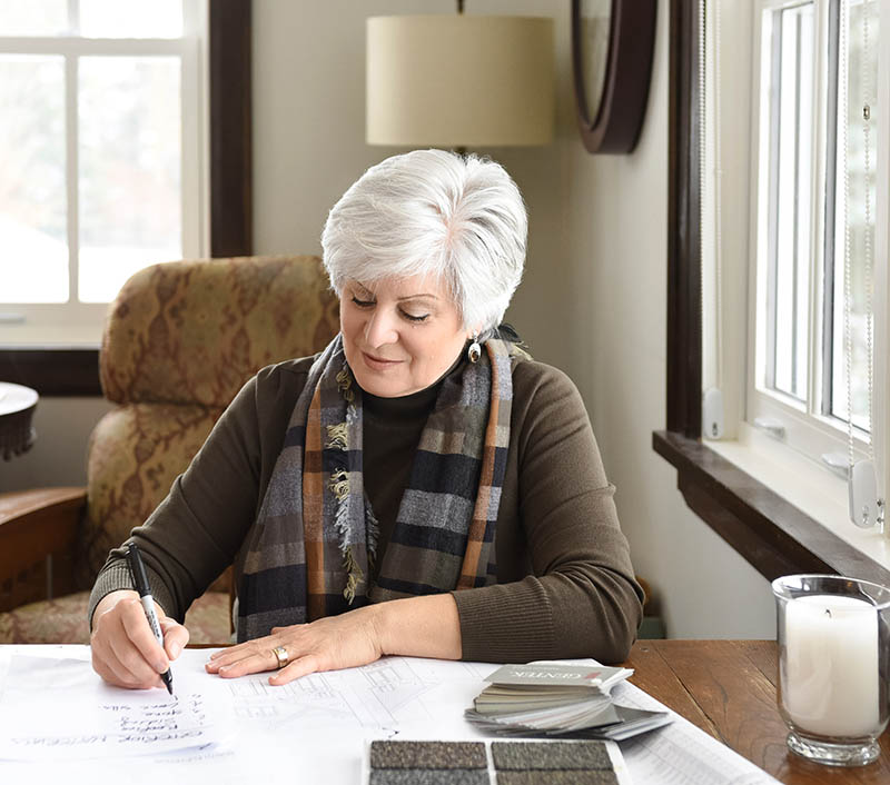 Jane Cameron sketching at a desk by a window