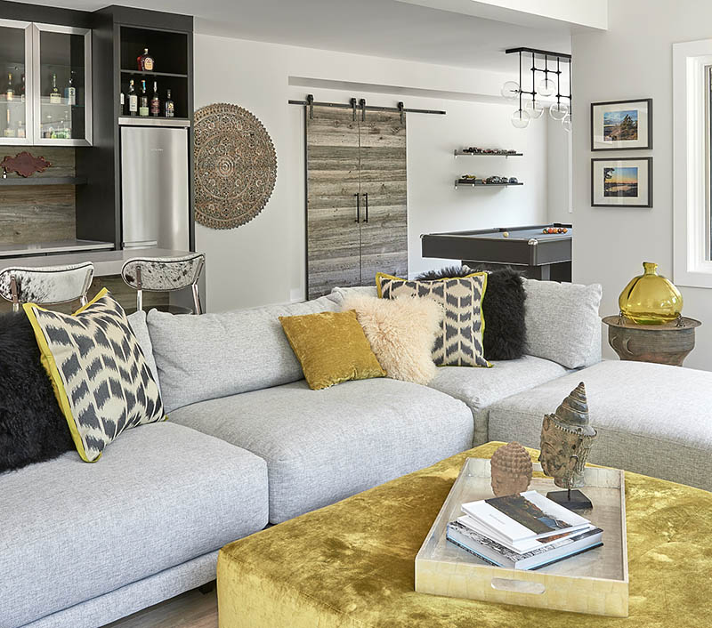 Living room at Beside the Brook with a grey sectional and gold ottoman