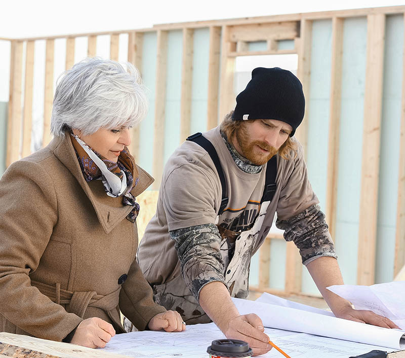 Jane Cameron reviewing drawings with a builder on site