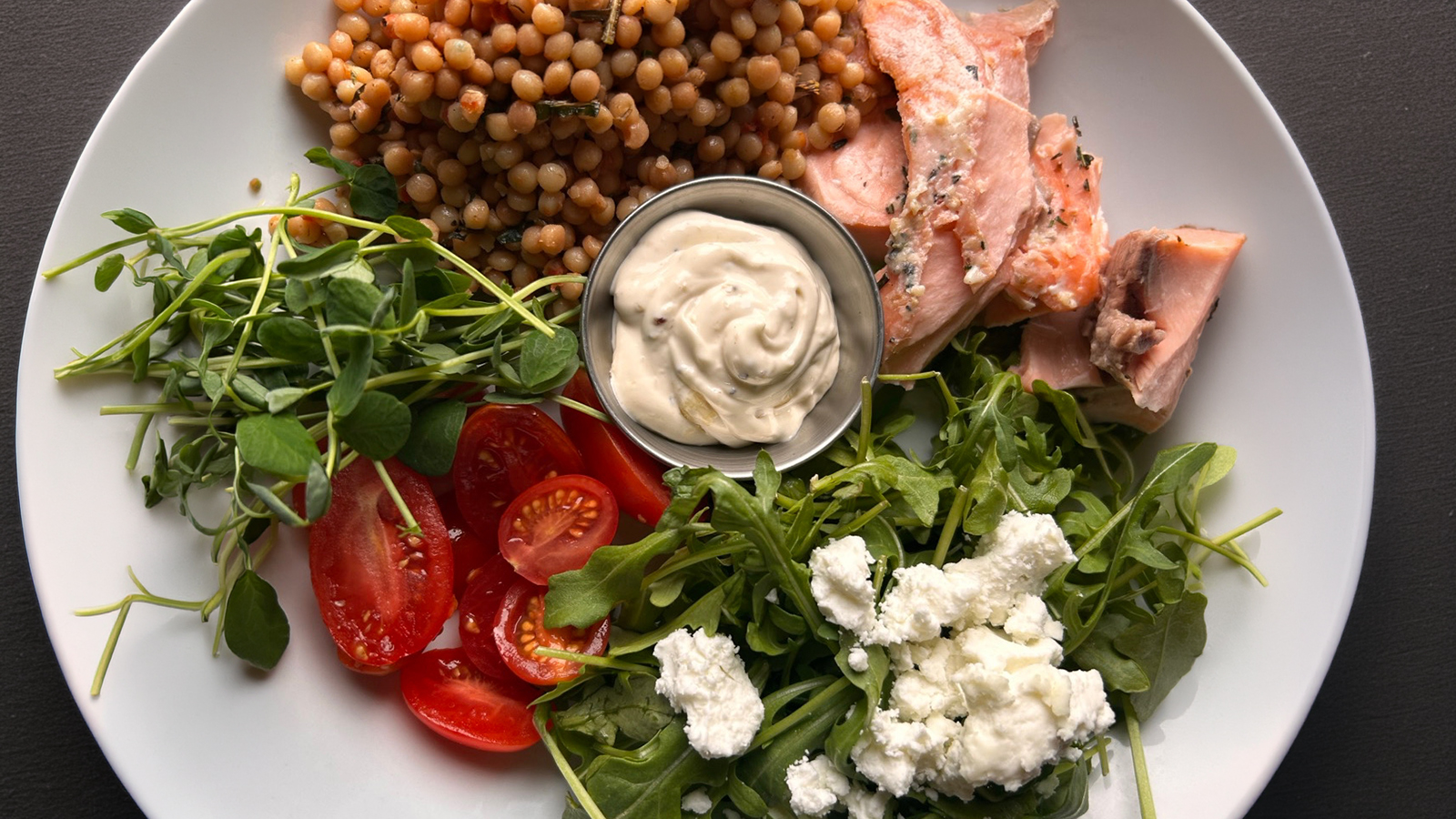 Salmon with pearl couscous and greens at The Curly Willow Eatery