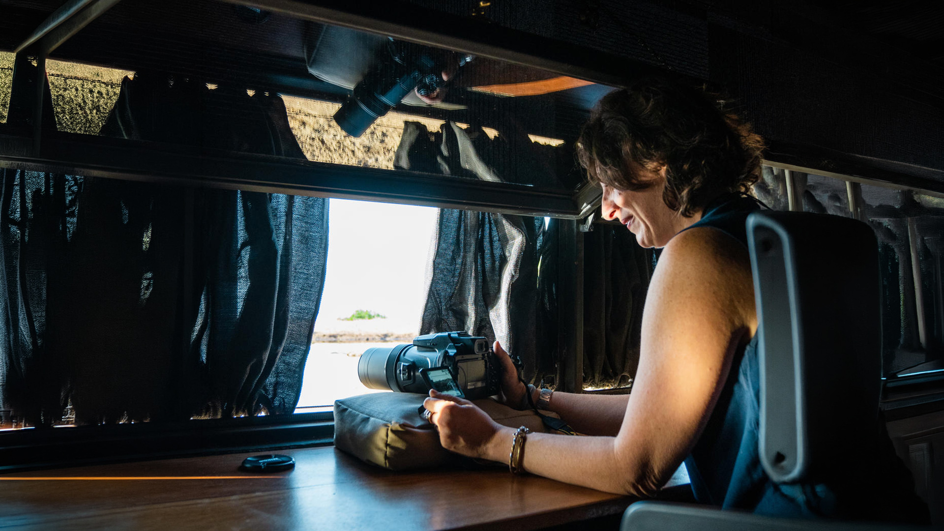 Guest photographing wildlife from inside a private 4x4 safari vehicle