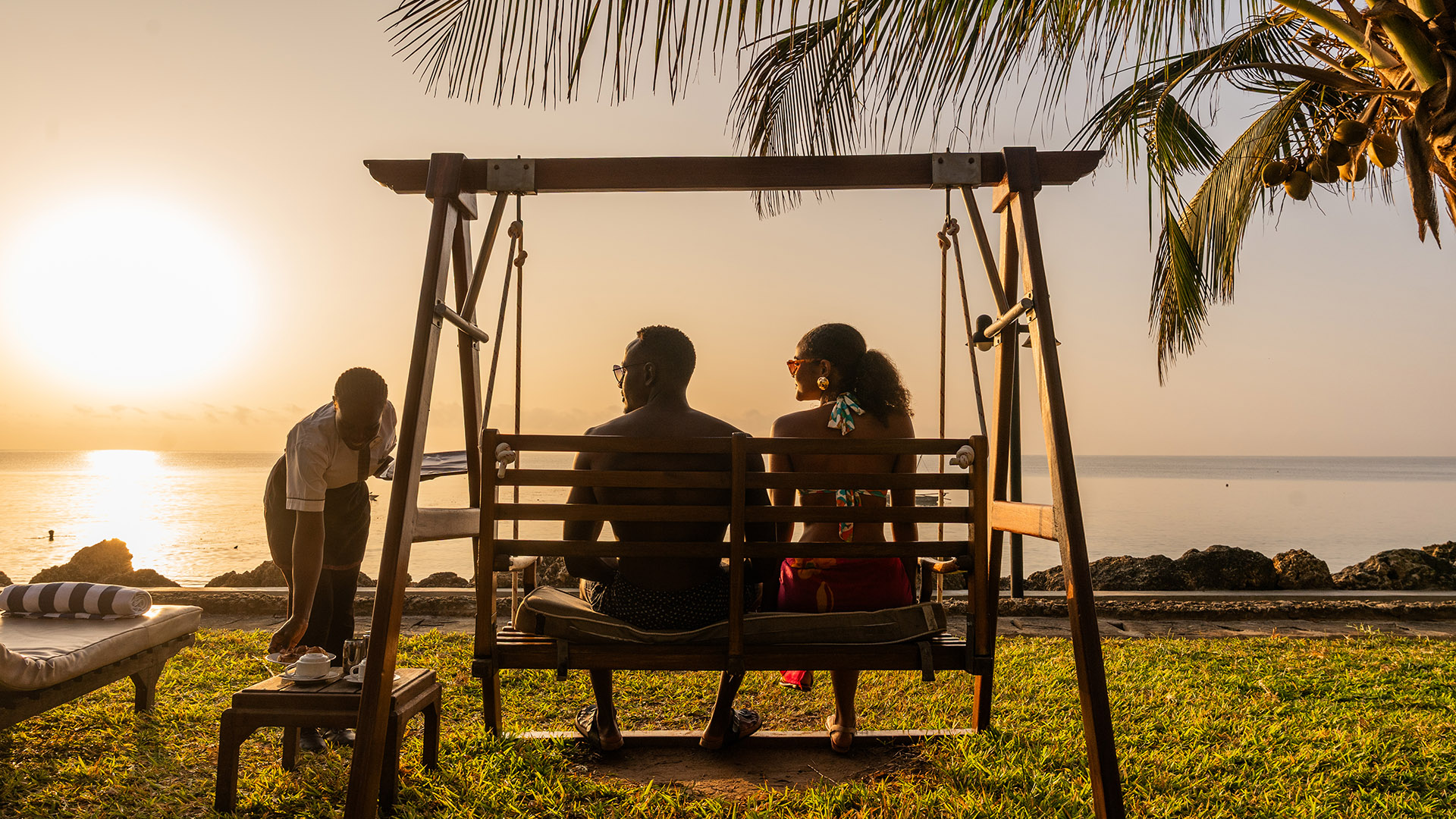 Couple watching an ocean sunset from a porch swing at a North Coast beach resort