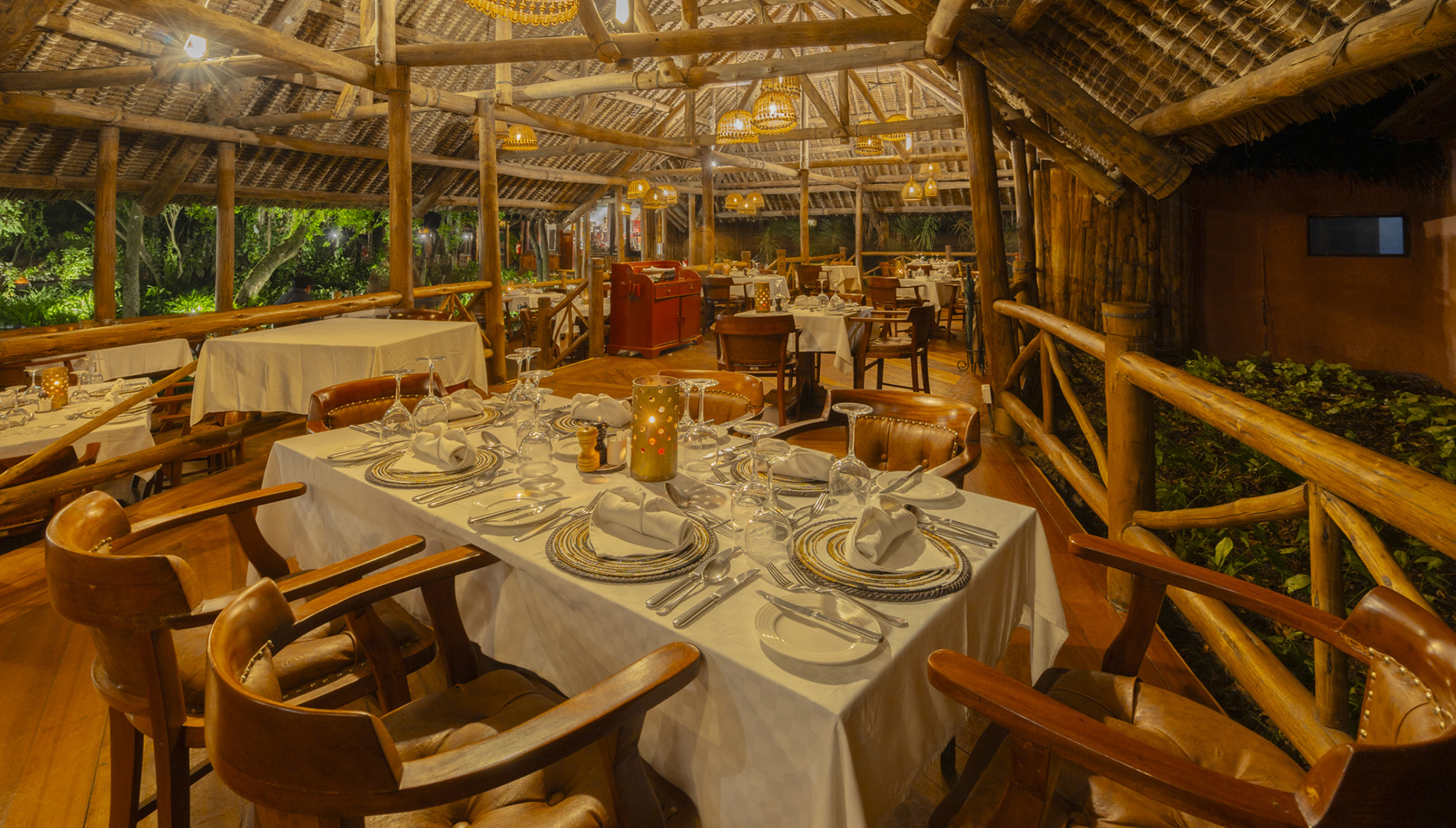 Open-air dining pavilion at a safari lodge in the Maasai Mara at night