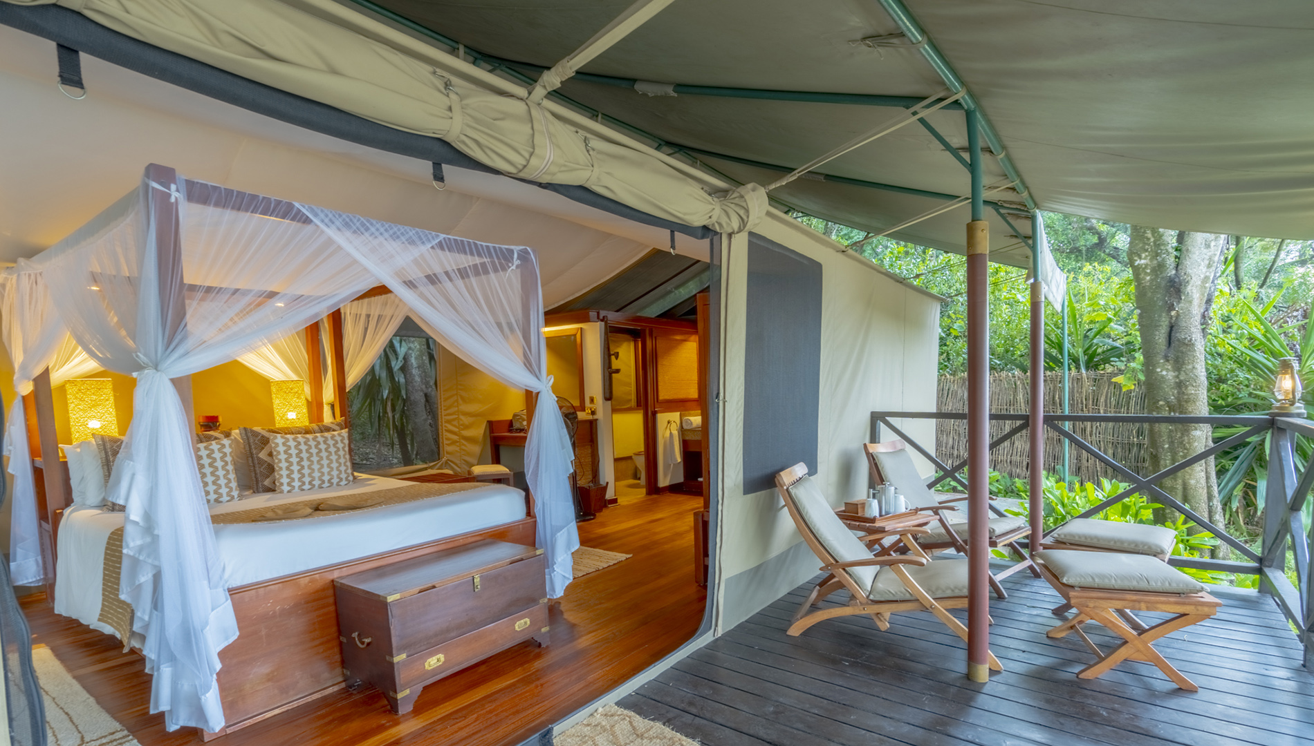 Luxury safari tent with four-poster bed and private deck overlooking the Maasai Mara