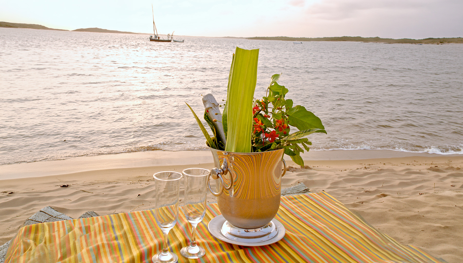 Champagne on ice with flutes set on the sand at a Mombasa beach at sunset