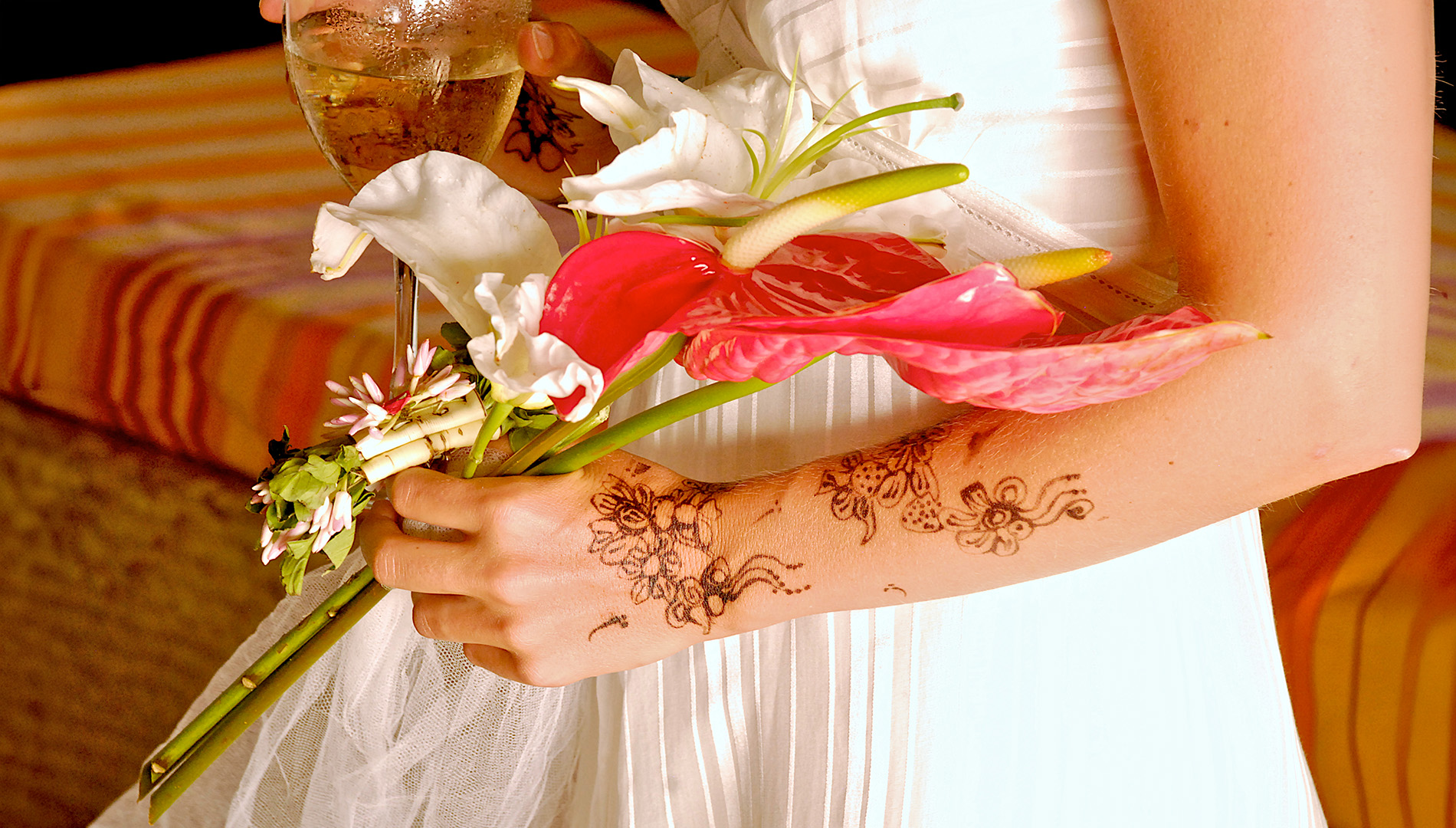 Tropical flower bouquet with henna-adorned hands at a celebration in Mombasa