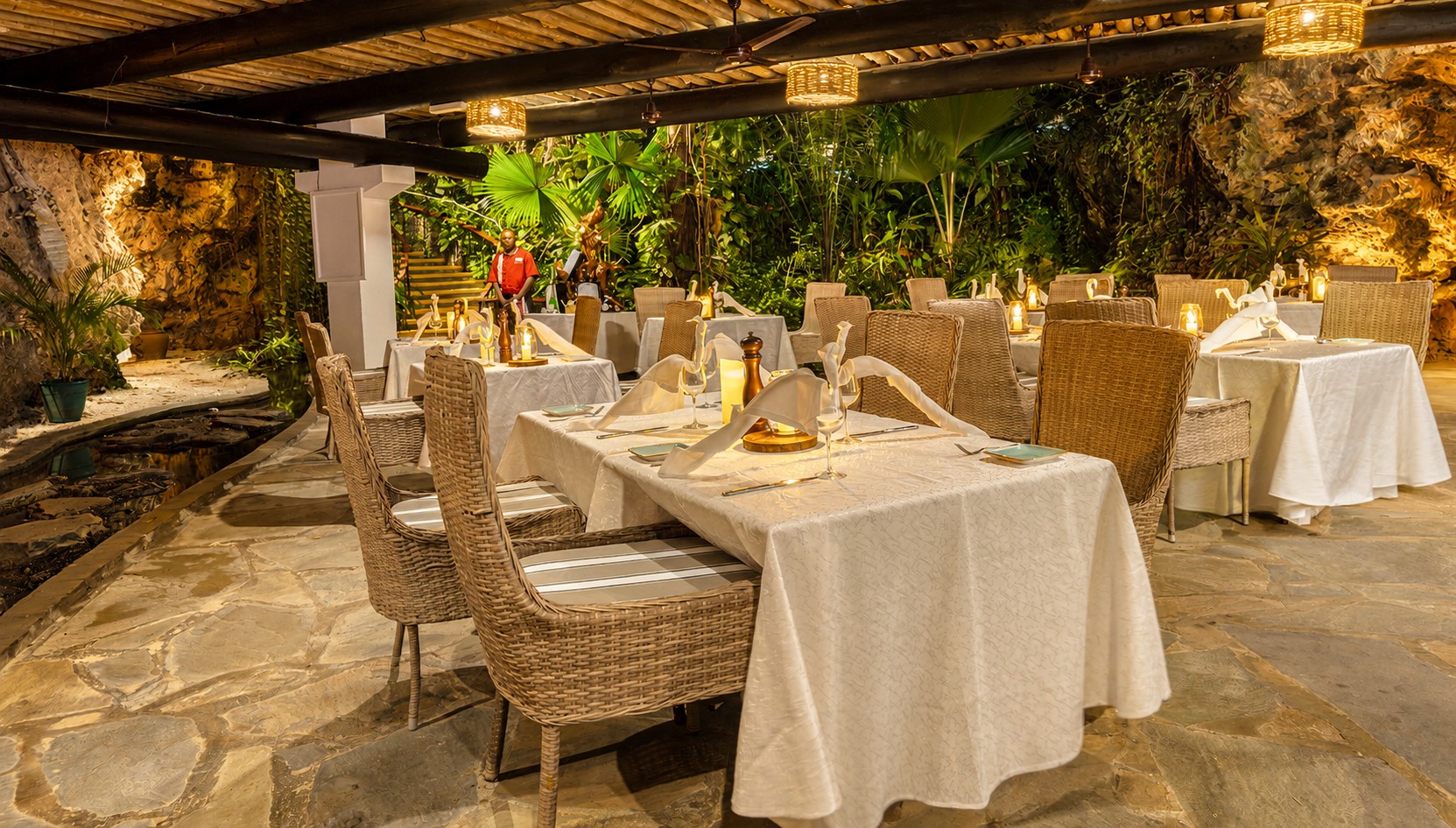 Open-air restaurant dining with wicker chairs and candlelit tables at Voyager Beach Resort, Mombasa