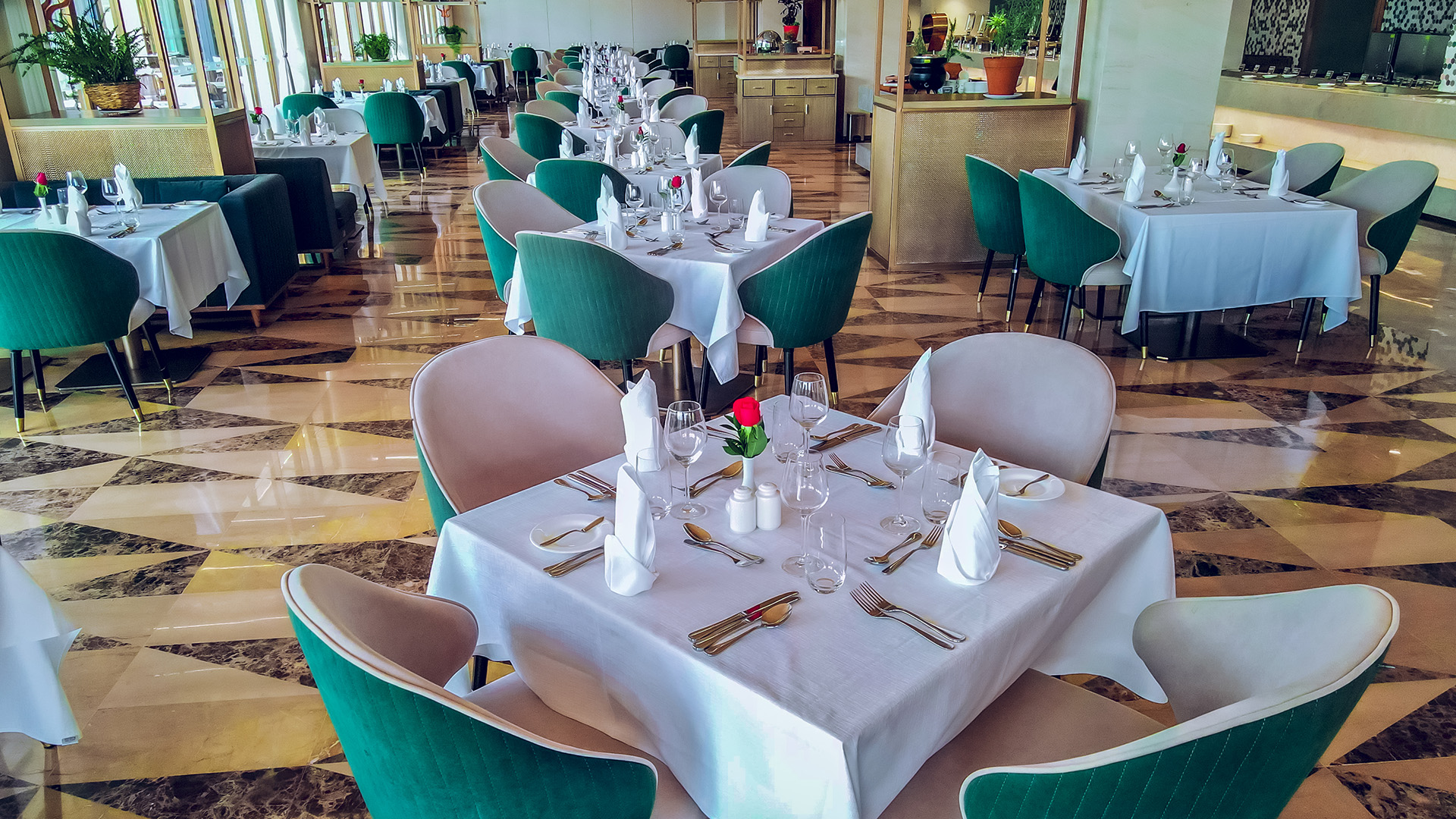 Formal hotel restaurant dining room with emerald green chairs at Argyle Grand
