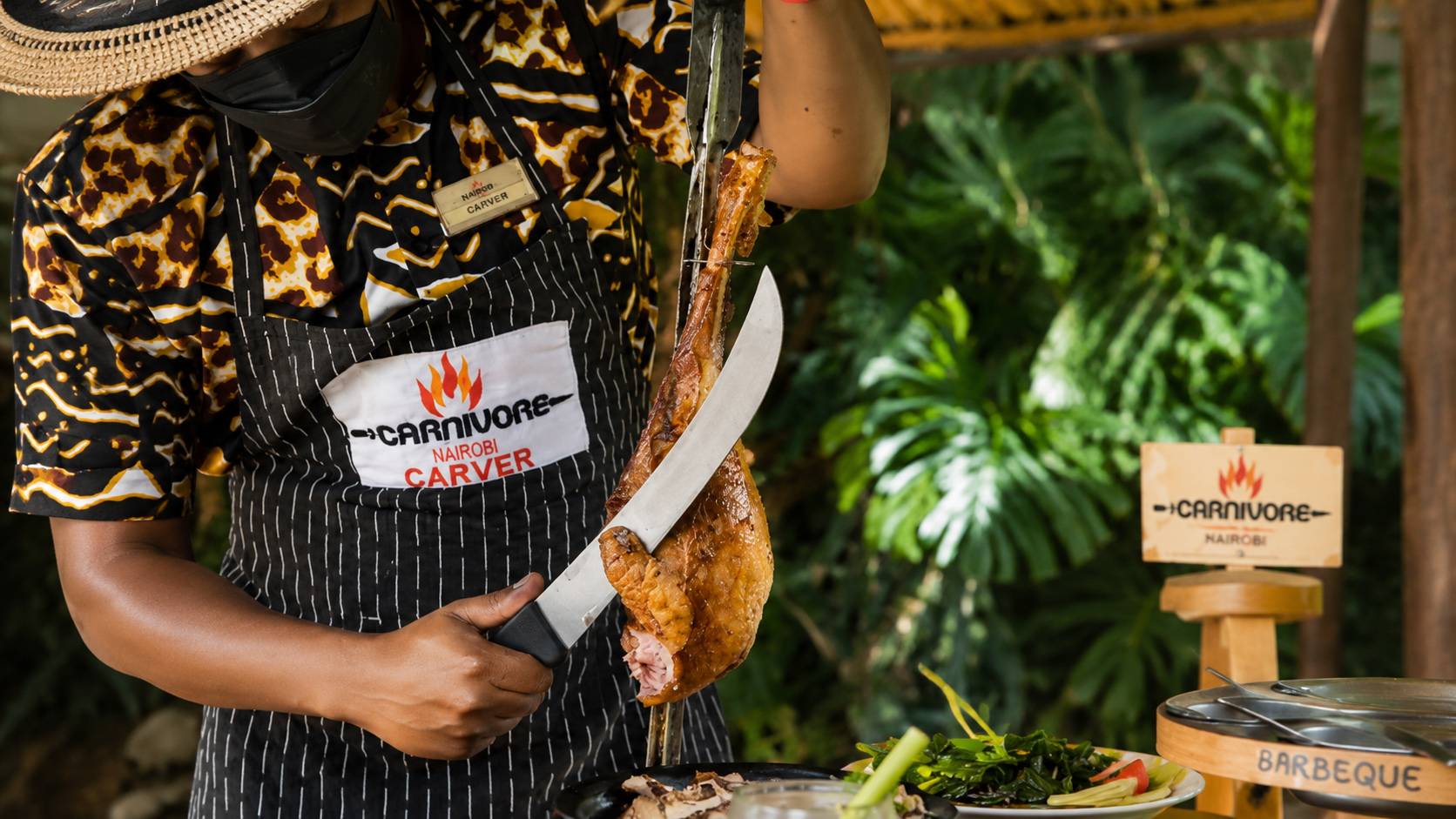 Carnivore Nairobi carver slicing roast meat at the open-fire restaurant