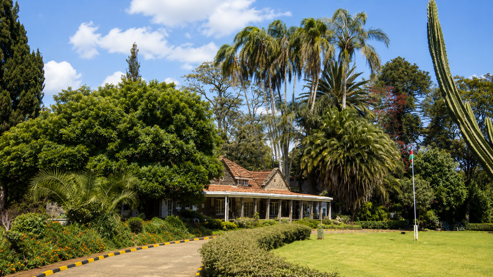 Karen Blixen Museum stone farmhouse and gardens with Kenyan flag, Nairobi