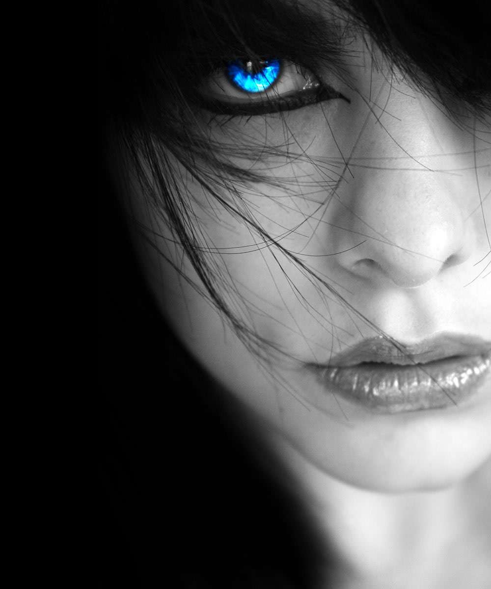 Black and white close-up of a woman's face with one vivid blue eye